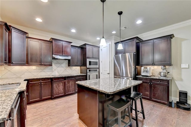 kitchen featuring light hardwood / wood-style floors, a center island, stainless steel appliances, and hanging light fixtures