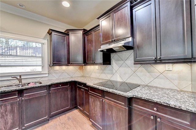 kitchen with black electric cooktop, crown molding, light wood-type flooring, light stone counters, and tasteful backsplash