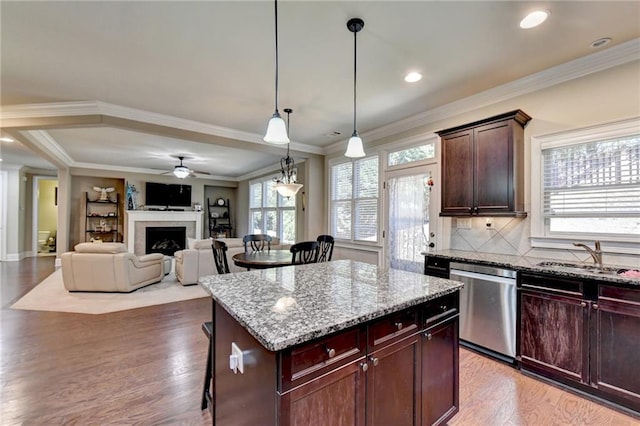 3191 Lake Mcginnis Dr, Suwanee, GA 30024 - kitchen with stainless steel dishwasher, a sink, a kitchen breakfast bar, light wood finished floors, and light stone counters