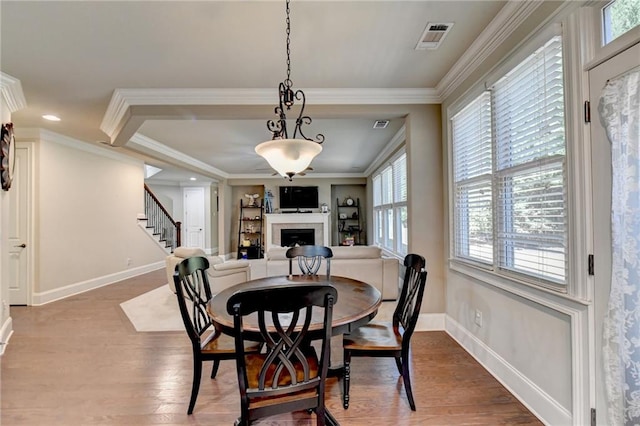 dining space featuring ornamental molding and hardwood / wood-style floors