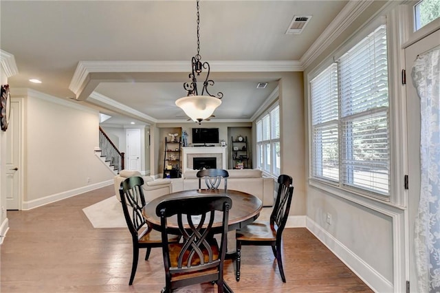 3191 Lake Mcginnis Dr, Suwanee, GA 30024 - dining space featuring a fireplace, baseboards, wood finished floors, ornamental molding, and stairs