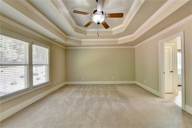 carpeted spare room featuring crown molding, a raised ceiling, and ceiling fan