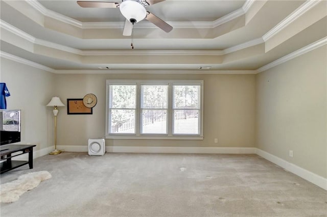 interior space with crown molding, light colored carpet, a tray ceiling, and ceiling fan