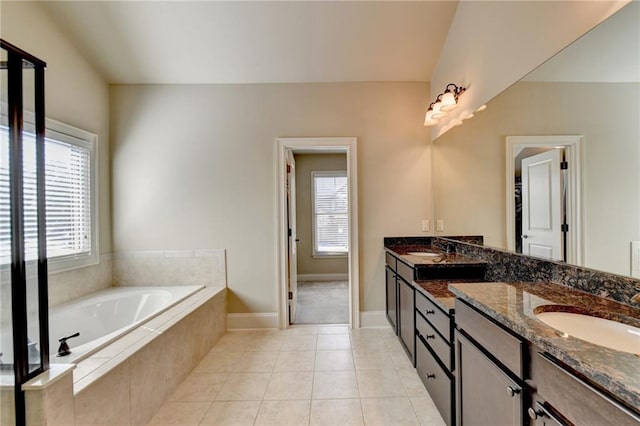 bathroom featuring vanity, tile patterned floors, and tiled bath