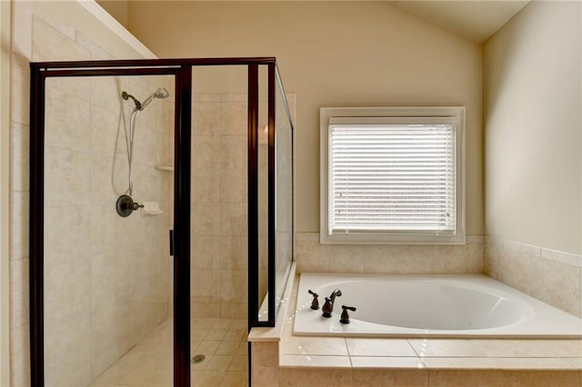 bathroom featuring lofted ceiling and independent shower and bath