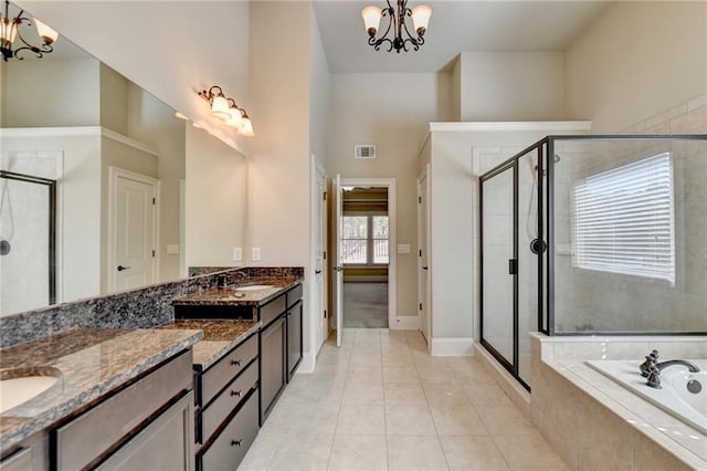 bathroom with separate shower and tub, a chandelier, a towering ceiling, vanity, and tile patterned floors