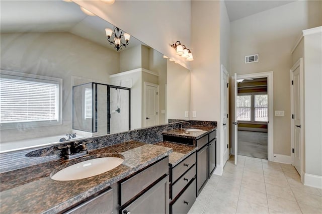 bathroom with shower with separate bathtub, an inviting chandelier, high vaulted ceiling, vanity, and tile patterned floors