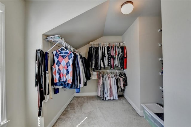 walk in closet featuring lofted ceiling and light carpet