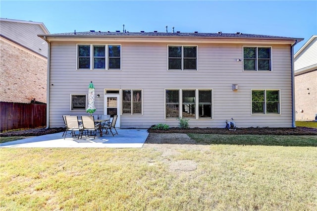 rear view of house featuring a patio area and a lawn