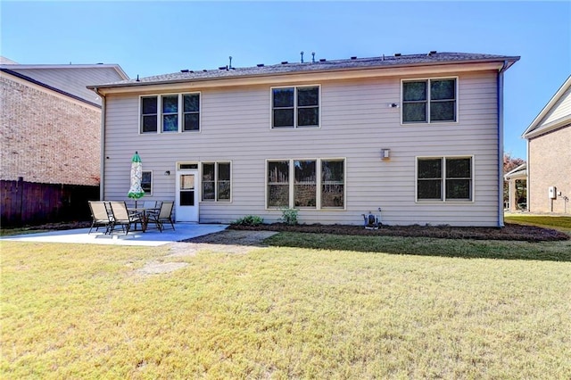 back of house with a patio area and a lawn