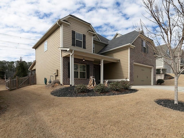 craftsman inspired home with a garage, driveway, brick siding, fence, and a front yard