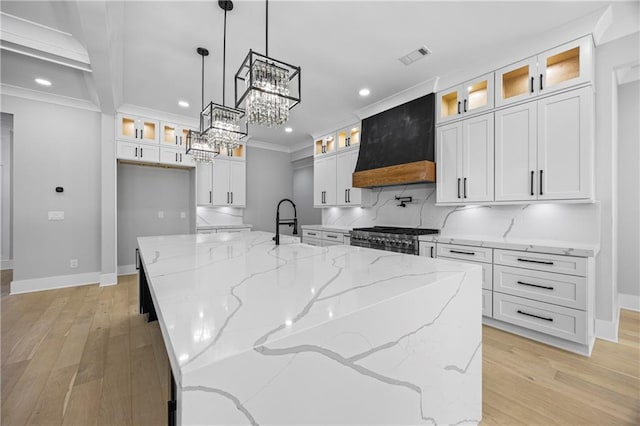407 Thunder Rd, Buford, GA 30518 - kitchen featuring recessed lighting, custom exhaust hood, high end stainless steel range, white cabinetry, and baseboards