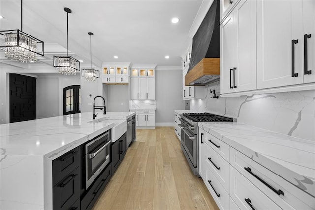 407 Thunder Rd, Buford, GA 30518 - kitchen featuring appliances with stainless steel finishes, a sink, custom range hood, a chandelier, and white cabinetry