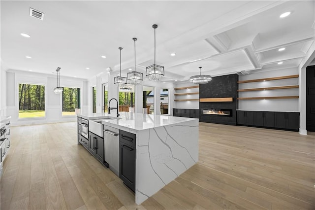 407 Thunder Rd, Buford, GA 30518 - kitchen with a sink, light wood-style floors, a spacious island, dark cabinetry, and a fireplace