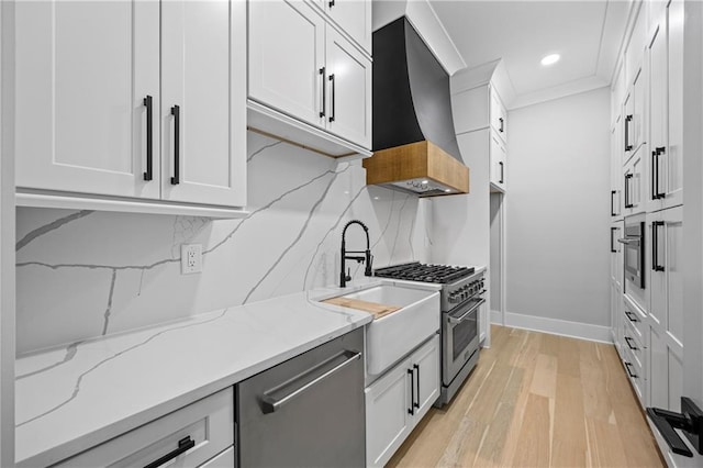 407 Thunder Rd, Buford, GA 30518 - kitchen featuring appliances with stainless steel finishes, extractor fan, light wood-style flooring, light stone countertops, and baseboards