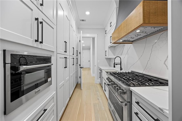407 Thunder Rd, Buford, GA 30518 - kitchen with premium range hood, high end stainless steel range oven, recessed lighting, crown molding, and light wood-style floors