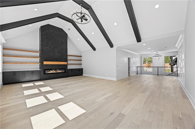 407 Thunder Rd, Buford, GA 30518 - unfurnished living room featuring a chandelier, beamed ceiling, a fireplace, wood finished floors, and recessed lighting