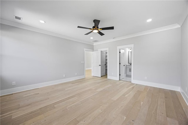 407 Thunder Rd, Buford, GA 30518 - unfurnished bedroom featuring crown molding, baseboards, light wood-style floors, a spacious closet, and connected bathroom