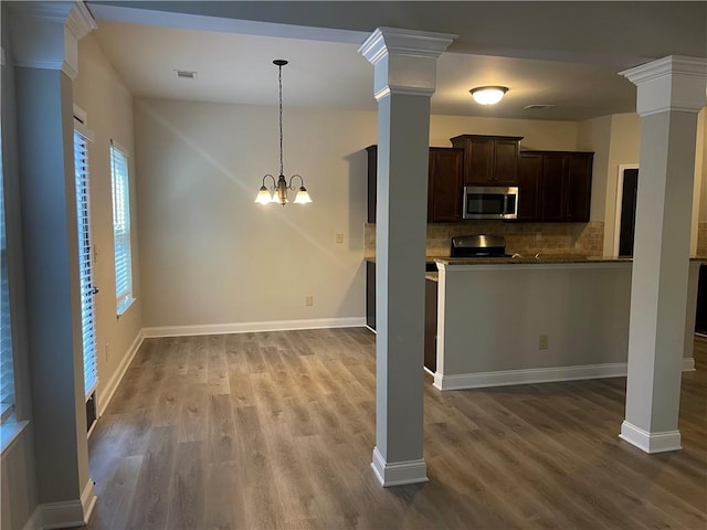 kitchen with ornate columns, tasteful backsplash, hardwood / wood-style flooring, and dark brown cabinetry