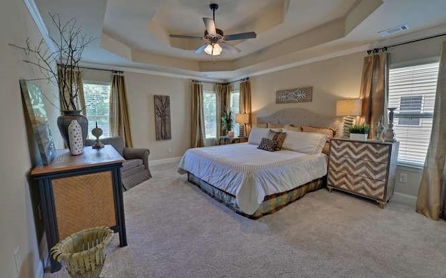 carpeted bedroom featuring ceiling fan and a tray ceiling