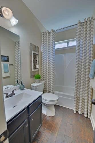 full bathroom with toilet, vaulted ceiling, vanity, shower / bathtub combination with curtain, and hardwood / wood-style floors