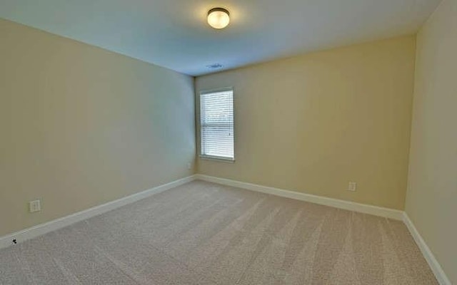 spare room featuring light carpet