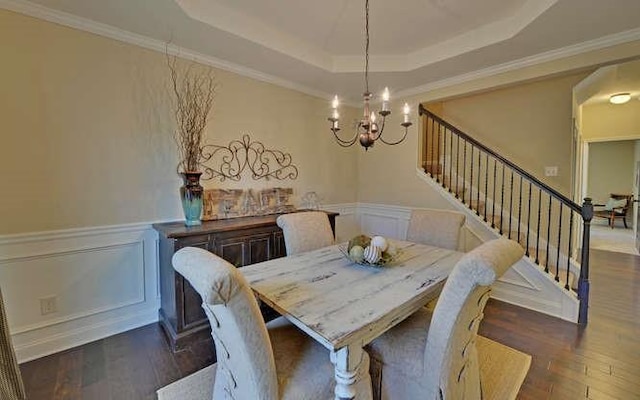 dining area featuring dark hardwood / wood-style floors, a tray ceiling, and an inviting chandelier