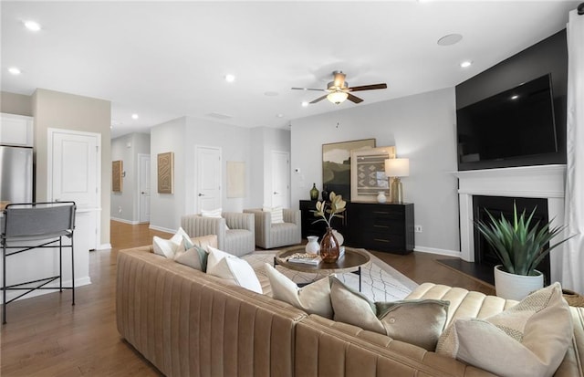 living room with ceiling fan and dark hardwood / wood-style flooring