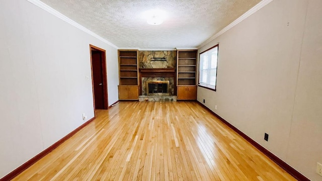 unfurnished living room with baseboards, crown molding, light wood-style floors, and a textured ceiling