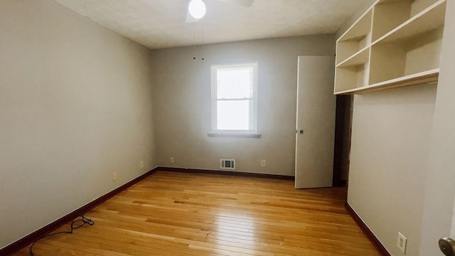 unfurnished bedroom with a closet, visible vents, light wood finished floors, baseboards, and ceiling fan