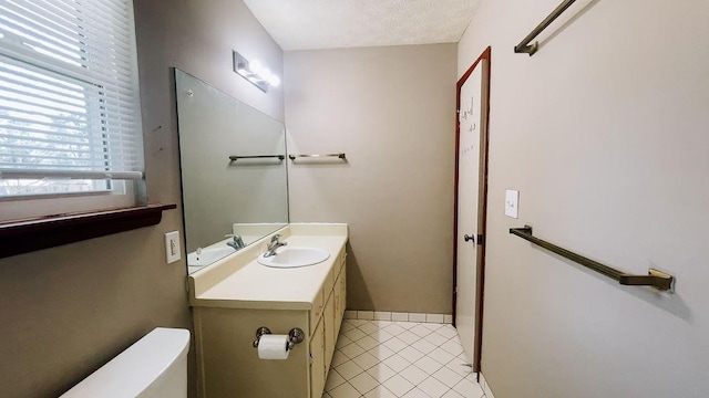 half bath featuring baseboards, toilet, tile patterned flooring, and vanity