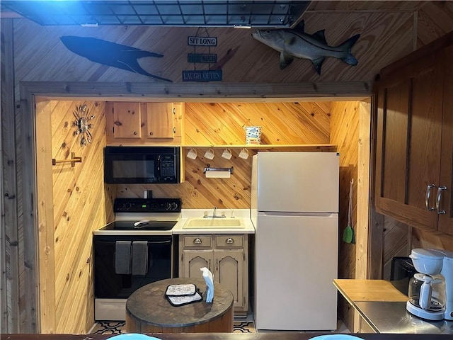 kitchen featuring black appliances, a sink, light countertops, and wooden walls