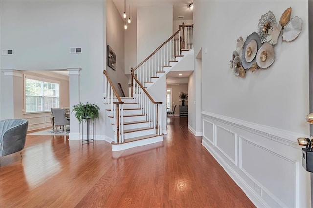 5613 Lancashire Ln, Cumming, GA 30041 - entryway with stairs, a towering ceiling, wood finished floors, wainscoting, and a decorative wall