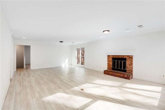 unfurnished living room featuring a fireplace, crown molding, and light hardwood / wood-style floors