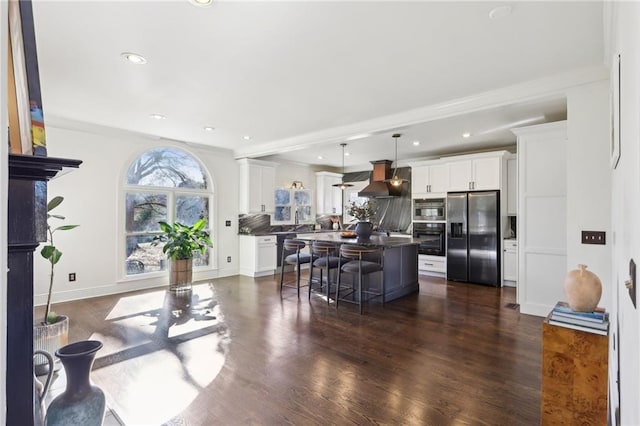 kitchen featuring a kitchen island, stainless steel fridge, a breakfast bar area, and white cabinets