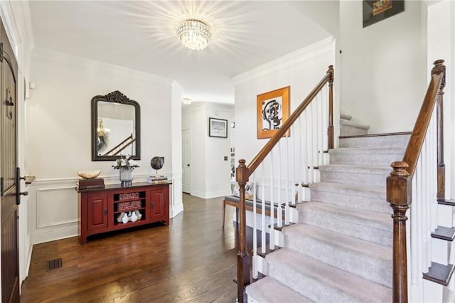 foyer entrance with crown molding and dark wood-type flooring