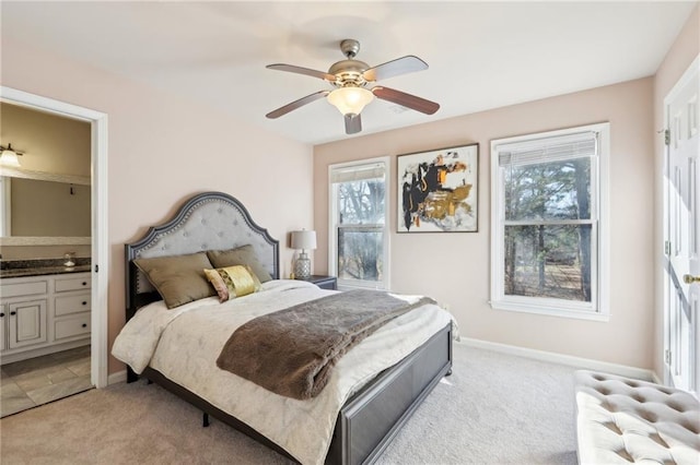 carpeted bedroom featuring multiple windows, radiator, ceiling fan, and ensuite bath