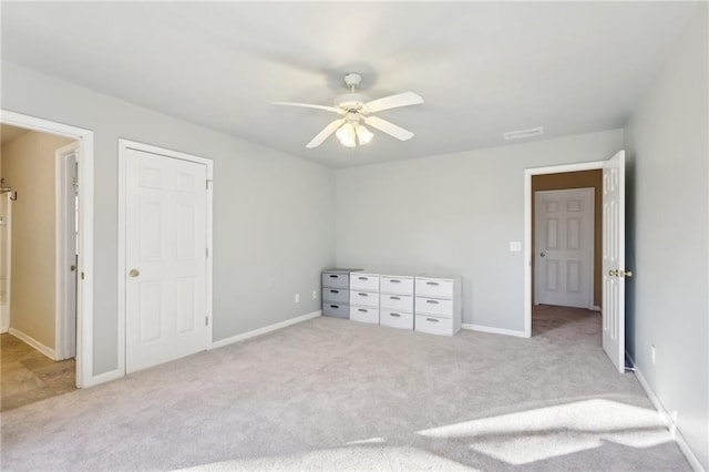 unfurnished bedroom featuring light carpet and ceiling fan