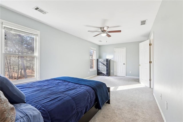 carpeted bedroom with multiple windows and ceiling fan