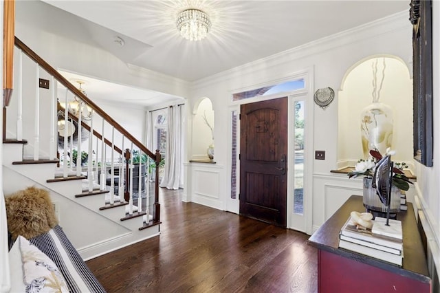 foyer entrance with crown molding, dark hardwood / wood-style floors, and a chandelier