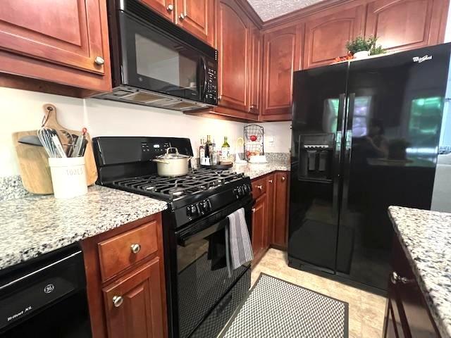 kitchen featuring black appliances and light stone countertops