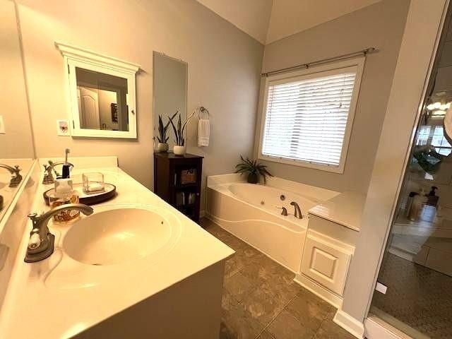 bathroom with a garden tub and double vanity