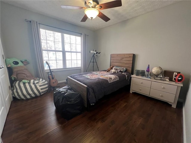 bedroom featuring dark wood finished floors, a textured ceiling, and ceiling fan