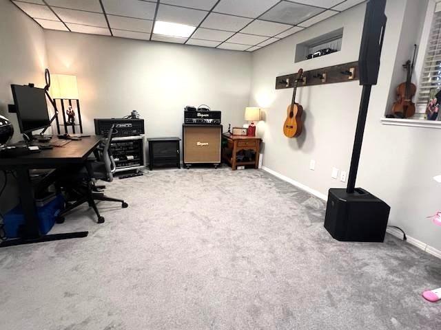 office featuring a drop ceiling, carpet, and baseboards