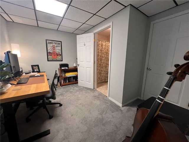 office area with carpet, a paneled ceiling, and baseboards