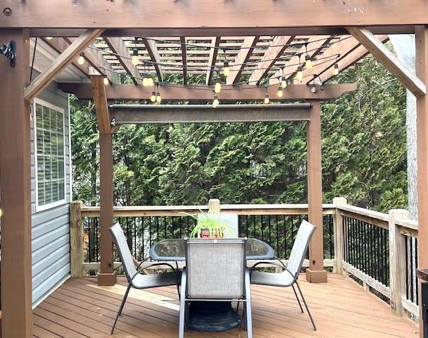 wooden terrace featuring a pergola and outdoor dining area