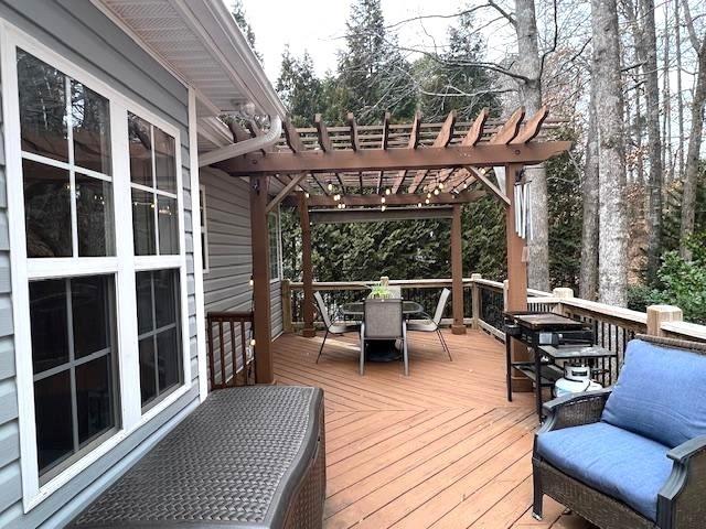 wooden terrace featuring outdoor dining area and a pergola