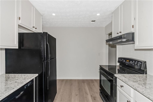 kitchen with white cabinets, under cabinet range hood, black appliances, and light wood finished floors