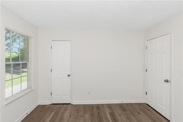 unfurnished bedroom with wood finished floors and baseboards