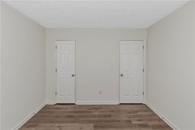 interior space with baseboards and wood finished floors